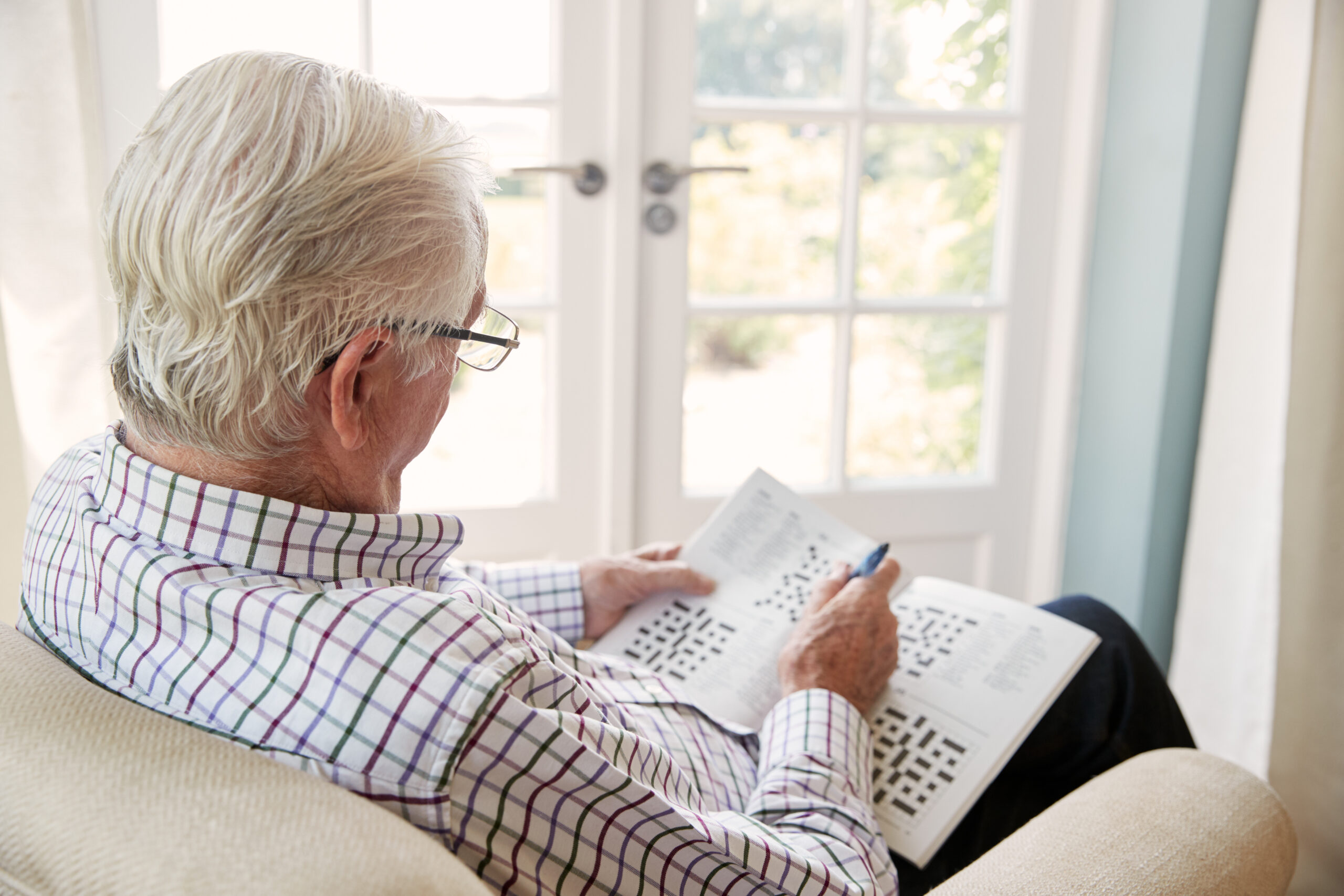 A senior doing a crossword puzzle as a brain fitness exercise